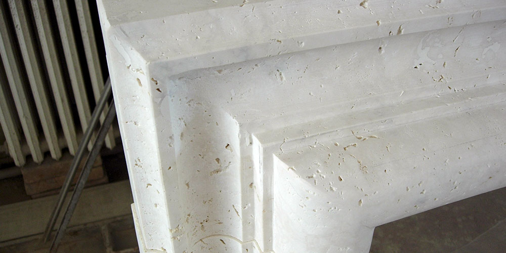 Tiglio, camino cornice artigianale in marmo travertino massello realizzato da Caminetti Carfagna